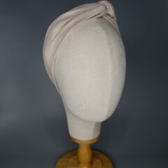 A light cream coloured bandana with aluminum wire. The bandana is wrapped around the head of a mannequin.