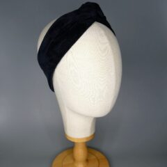 A black corduroy bandana with aluminum wire. The bandana is wrapped around the head of a mannequin.