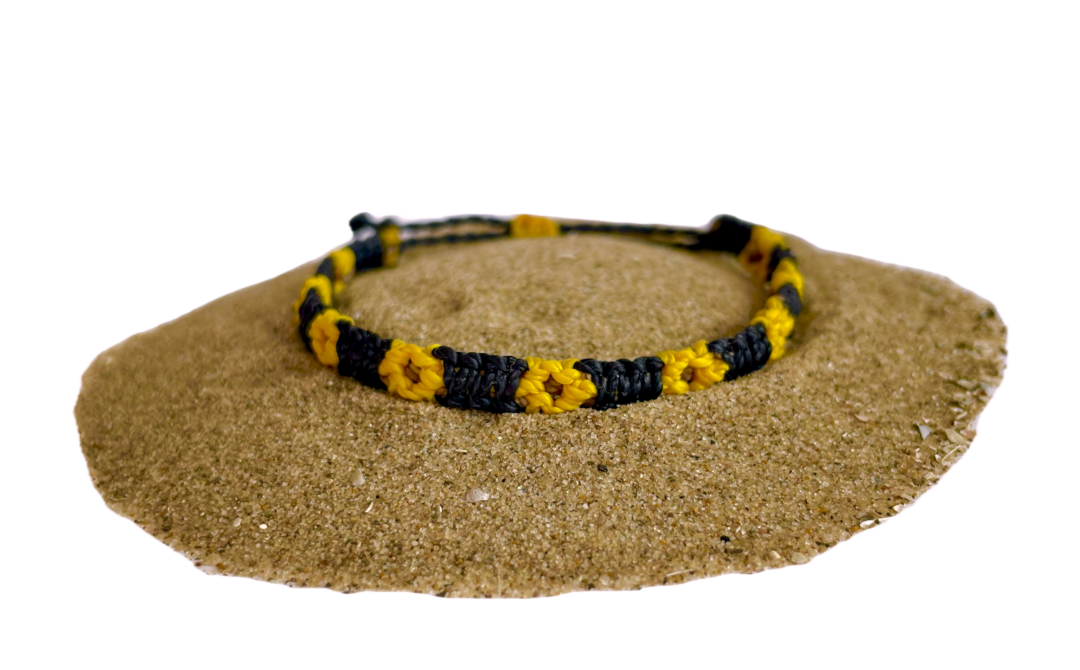 Geknoopte armband met zonnebloemen. De bloem is geel en het bandje is zwart.